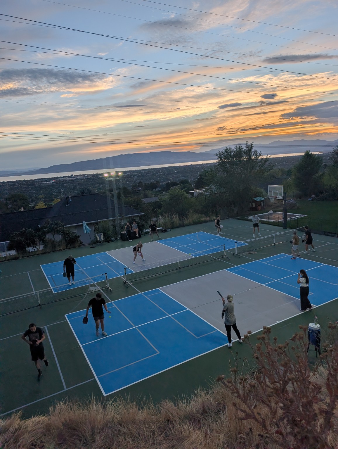 Pickleball games at sunset with the valley and mountains in the distance