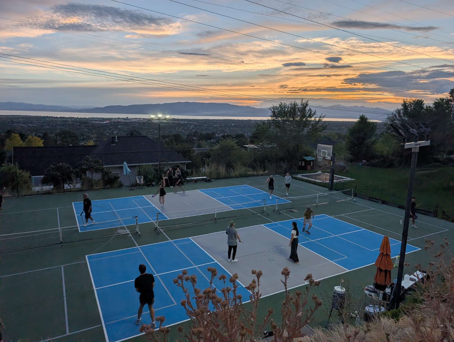 Players enjoying pickleball on the Devonshire courts at sunset overlooking Utah Valley